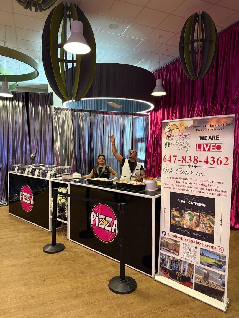 Nav tossing dough at the live pizza booth with pink draping and PIZZA branded counters