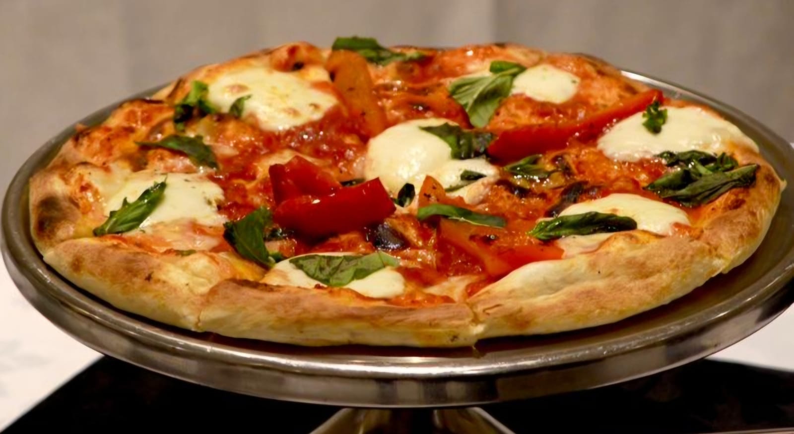 Specialty Margherita — Tomato sauce base, fresh mozzarella cheese, bocconcini cheese, sweet cherry tomatoes & fresh basil leaves with a drizzle of balsamic glaze.