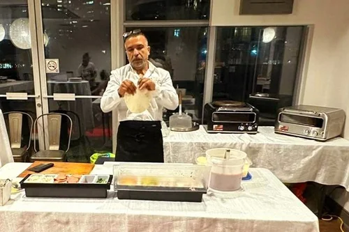 Chef preparing pizza dough live at an indoor event