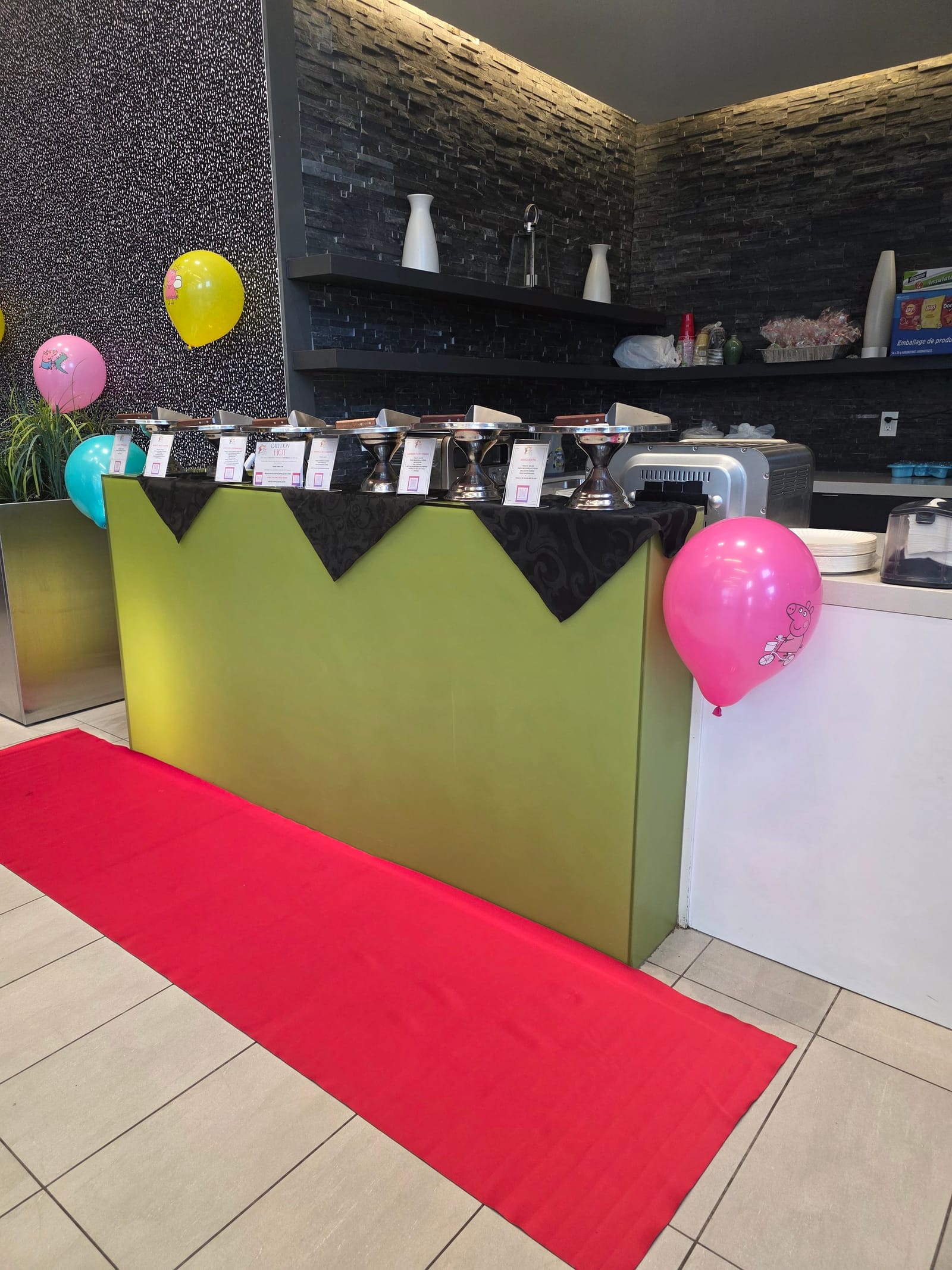 Live pizza station with balloons and a red carpet set up for a birthday party