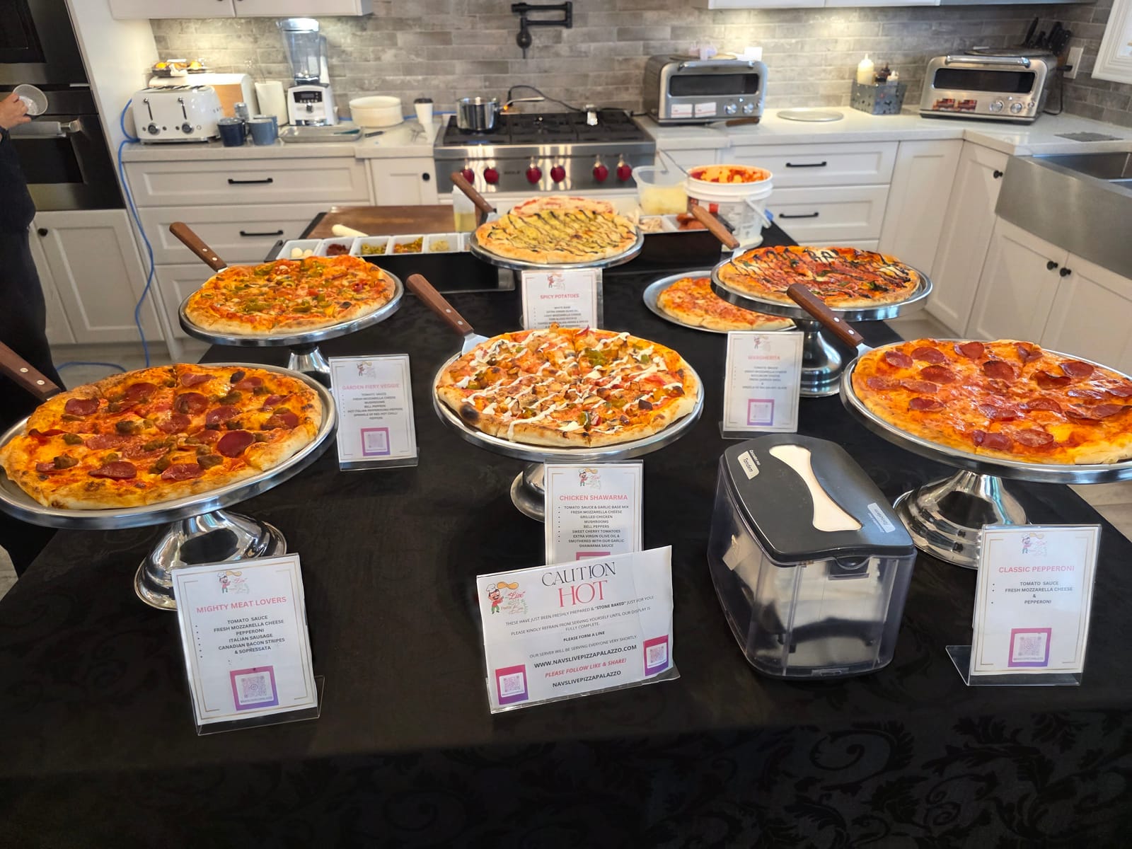 Full Six in the Six pizza display on silver stands in a home kitchen with menu cards for each flavour