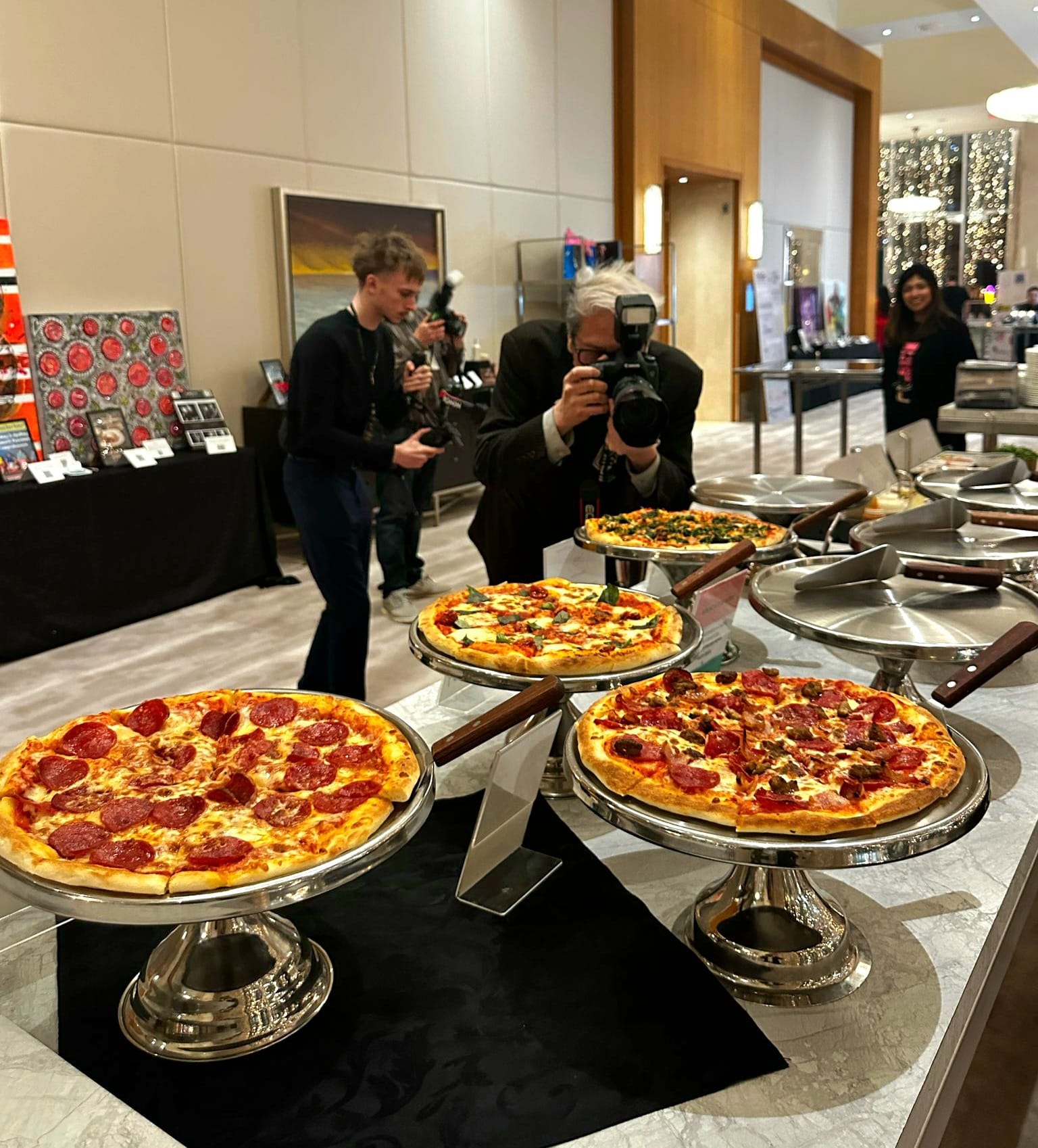 Live pizza display of fresh stone-baked pizzas on silver stands at a Ritz-Carlton wedding reception