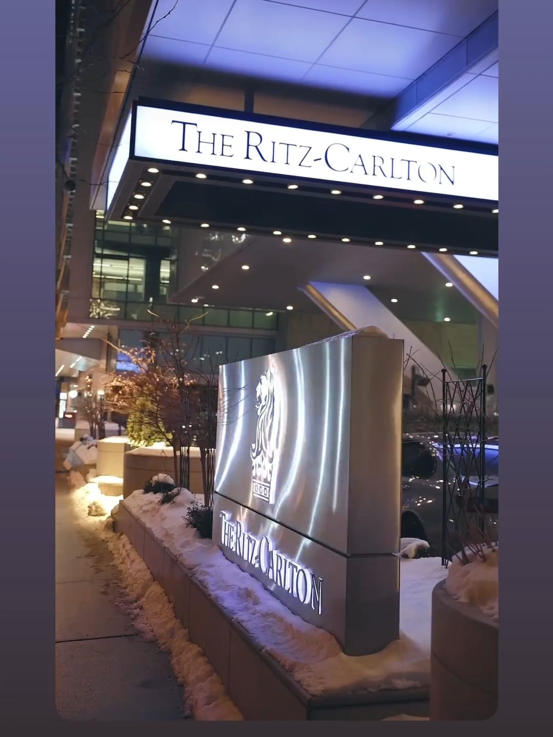 The illuminated Ritz-Carlton Toronto exterior sign and entrance at night in winter